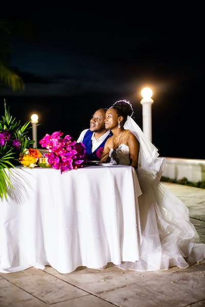North Carolina destination wedding planner- Jamaican destination wedding - Moon Palace Jamaica- Jamaican wedding reception - bride and groom at sweetheart table - just married in Jamaica