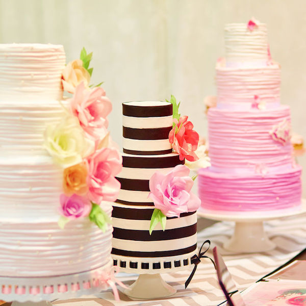 Three different wedding and event cakes on a dessert table